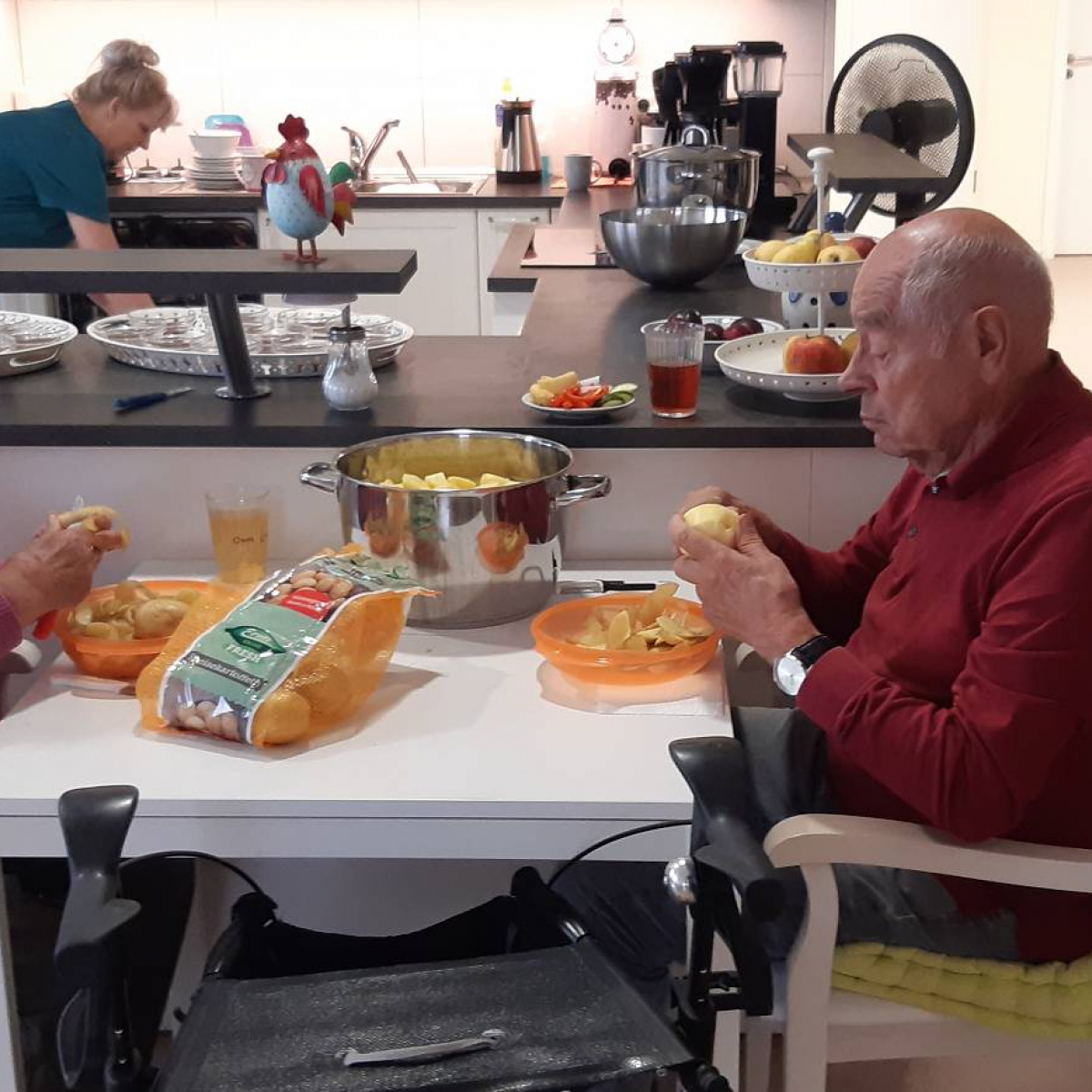 Senioren am Tisch beim Kartoffelschälen