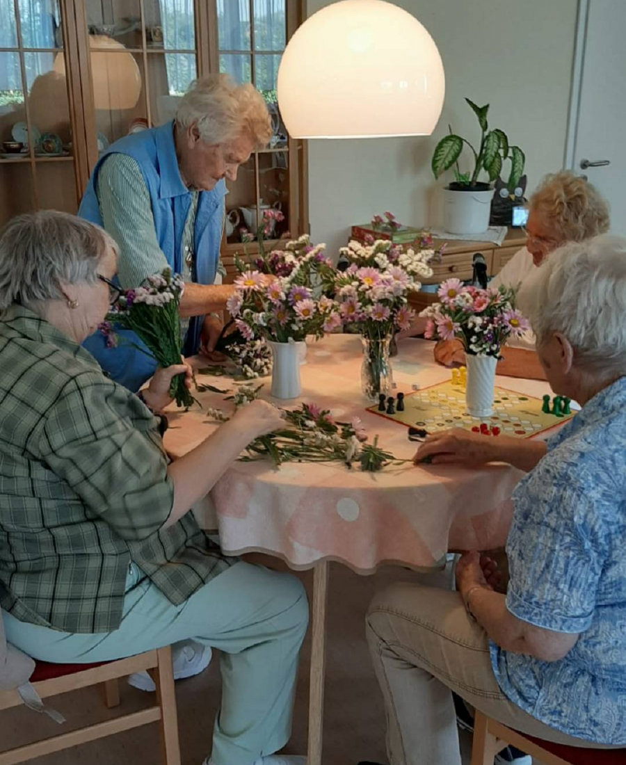 Senioren machen Blumensträuße am Tisch