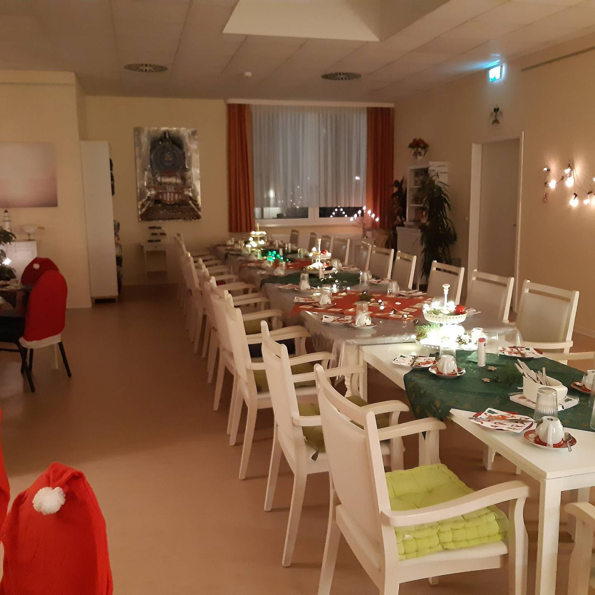 Raum mit Weihnachtsbaum und langen Tisch mit Weihnachtsdeko