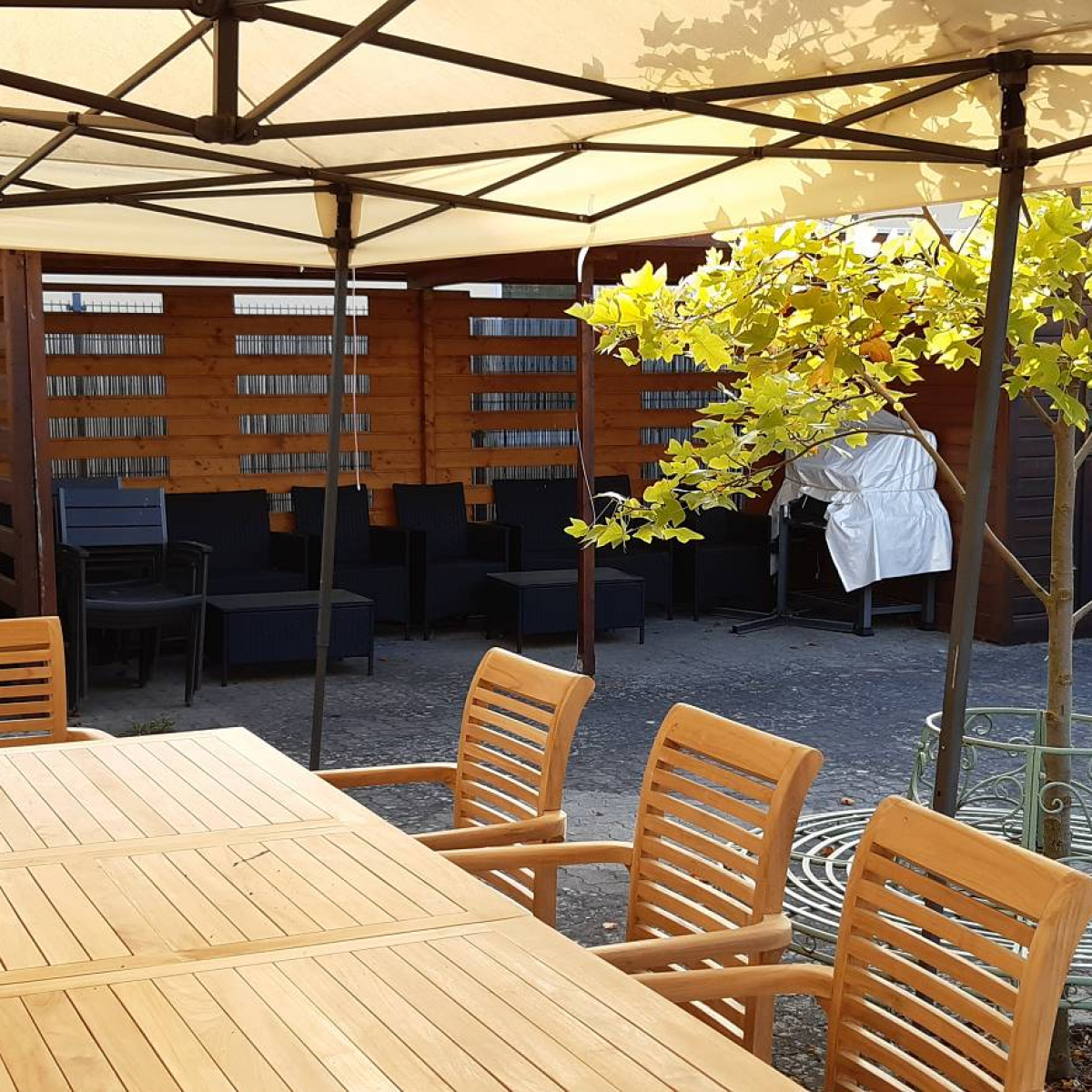 Terrassenbereich mit Tischgarnitur unter Pavillon